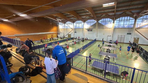 Vue d'ensemble de la salle et des tables pendant le tournoi, depuis les gradins