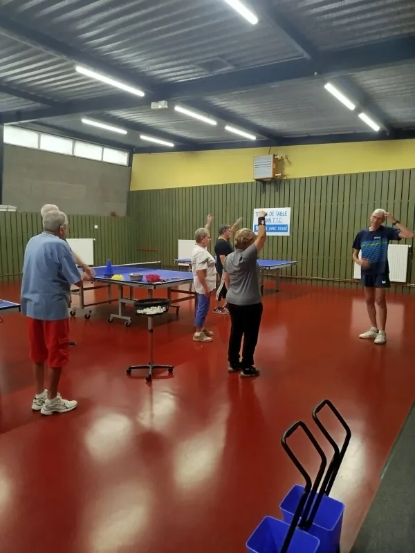 Participants bras levés pendant un exercice de mobilité, première séance de Ping Parkinson